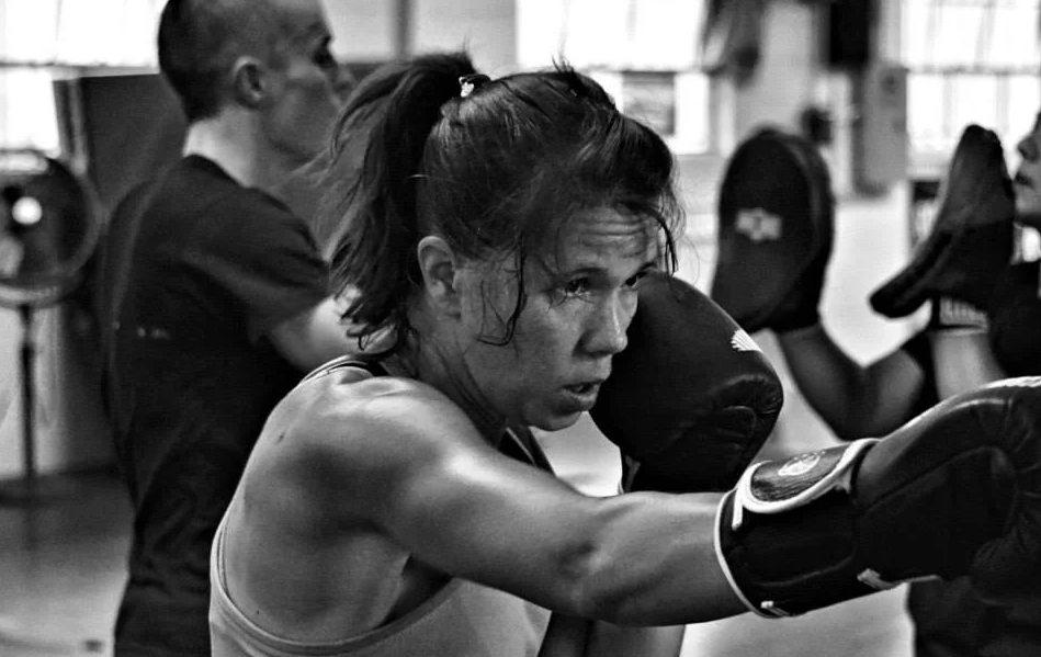 Woman practicing Muay Thai striking and boxing combinations during training