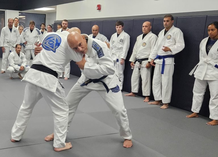 Royce Gracie demonstrating Brazilian Jiu Jitsu grappling techniques during academy instruction